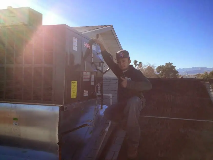 HVAC technician performing AC Tune-Up on a rooftop unit in Kirksville